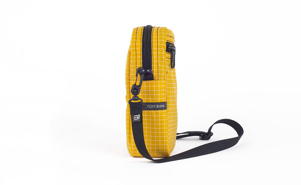 A side view of the Everyday Cubelet in Solaris Halcyon (yellow with a white grid) showing the o-ring attachment point and included 5/8" strap.